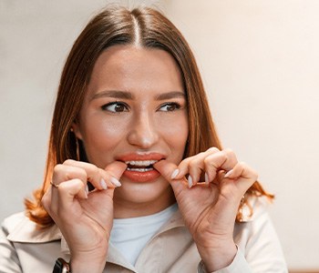Patient putting on clear aligner in treatment room