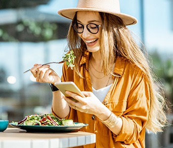 Woman smiling while eating lunch outside
