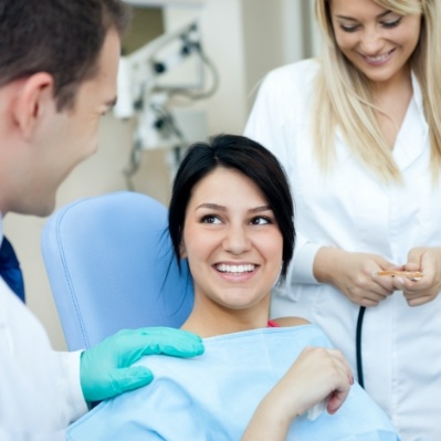 Dental patient smiling at compassionate team members