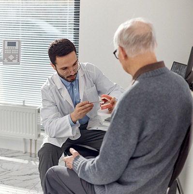 Older man meeting with a dentist to discuss oral health and hygiene