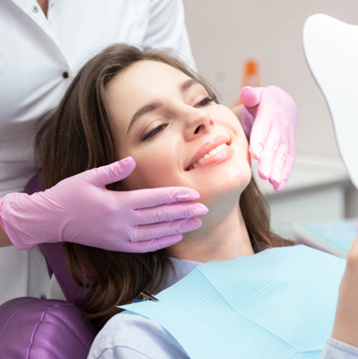 a patient admiring her smile following cosmetic dental bonding