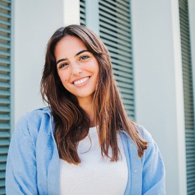 Woman with white teeth smiling while standing outside