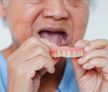 a man holding his dentures
