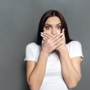 Woman with knocked out tooth covering her mouth