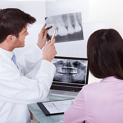 a dentist and patient reviewing an X-ray image