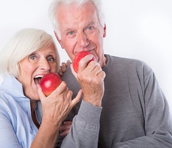 an older couple enjoying some apples 
