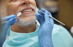 Dentist using dental tools to examine patient's teeth
