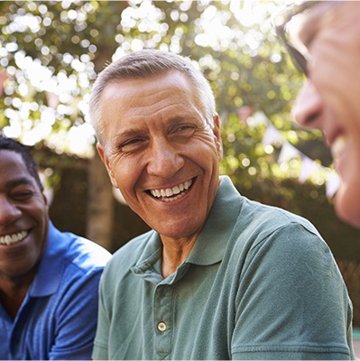 Man sharing flawless smile after dental implant tooth replacement