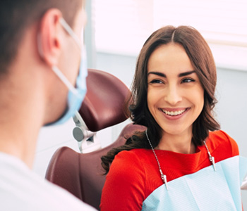 Woman smiling at dentist while sitting in treatment chair