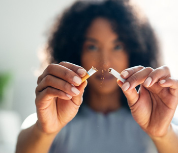 Closeup of woman breaking cigarette