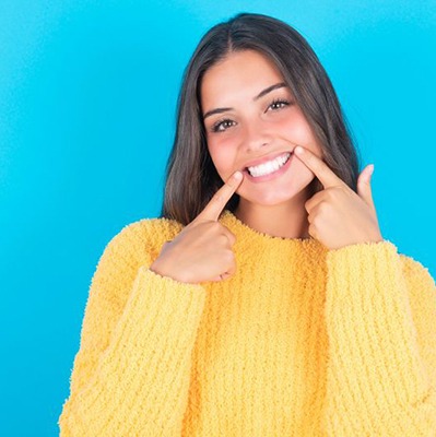 Woman in yellow sweater showing off her beautiful smile