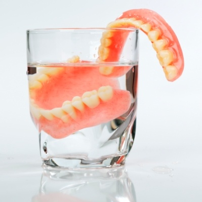 Full set of dentures in glass of water