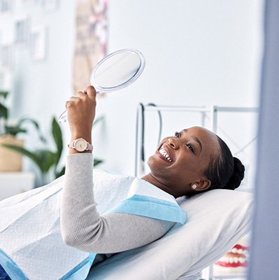Woman smiling while looking at reflection in mirror
