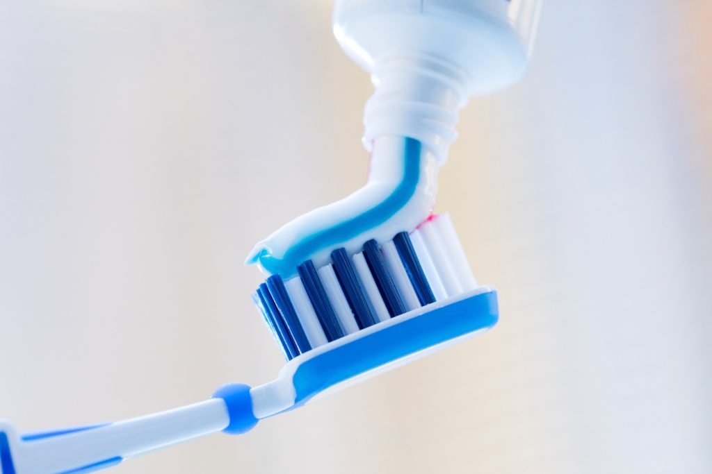Toothpaste being applied to soft-bristled toothbrush