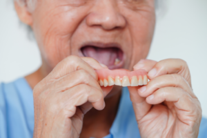 a closeup of a patient holding their dentures