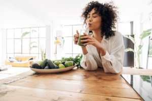 a person drinking a glass of juice
