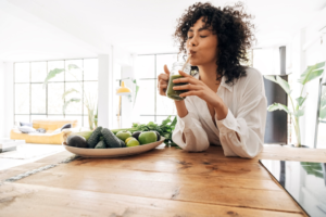 a person drinking a glass of juice 