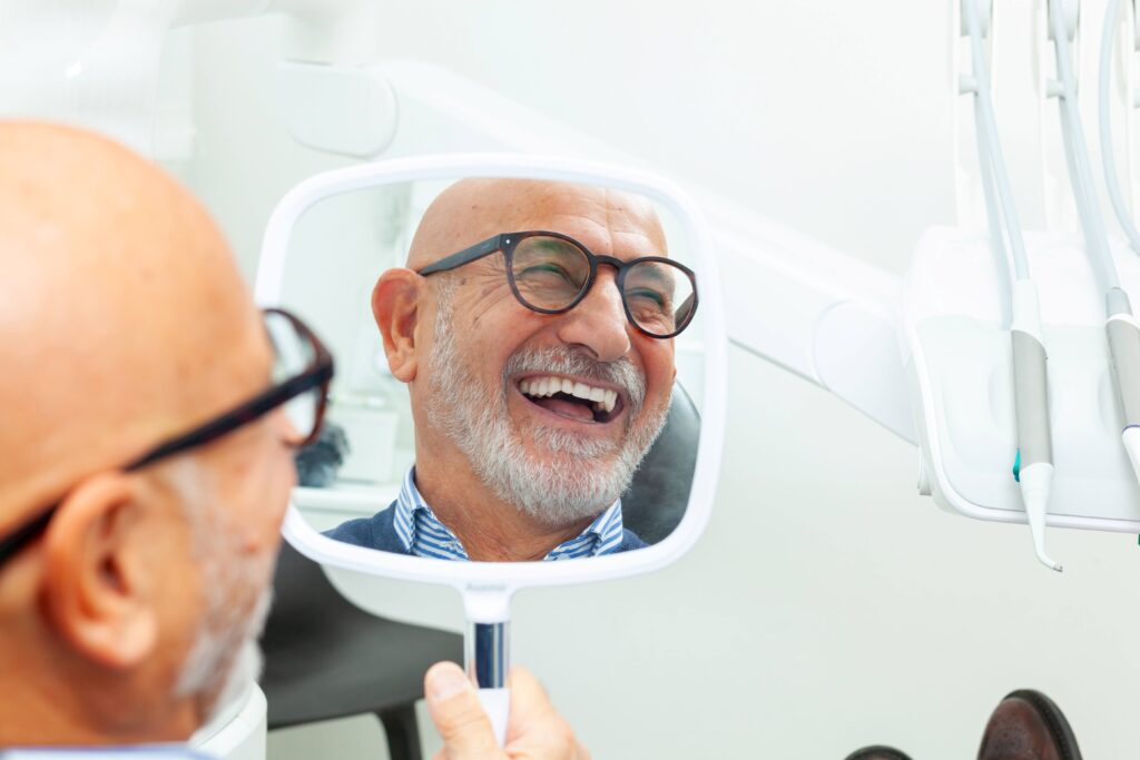 Man smiling while holding small mirror