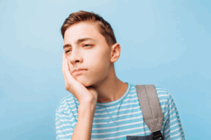 a teenager with a toothache due to an impacted wisdom tooth