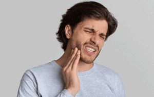 a patient holding their mouth in pain